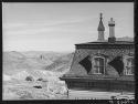 Corner of old mine office, abandoned mines in distance. Virginia City, Nevada